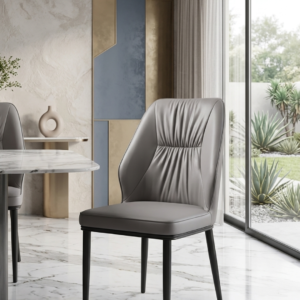 Premium taupe grey leatherette dining chair with pleated backrest design and sleek black metal legs viewed from the side profile in a modern home kitchen setup.