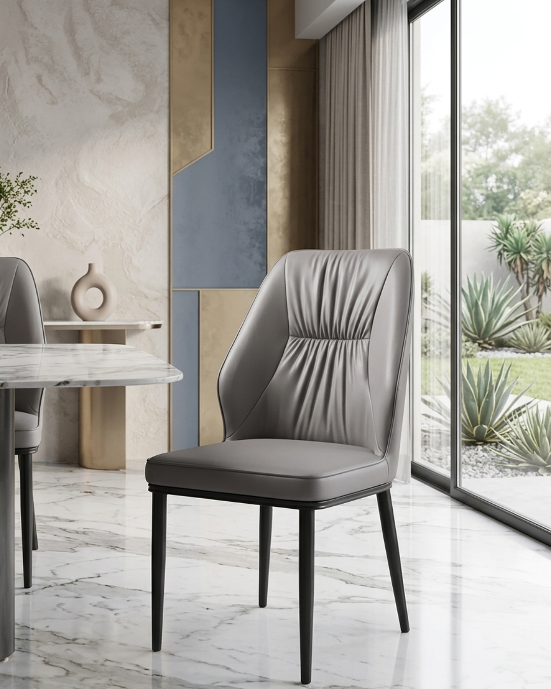 Premium taupe grey leatherette dining chair with pleated backrest design and sleek black metal legs viewed from the side profile in a modern home kitchen setup.
