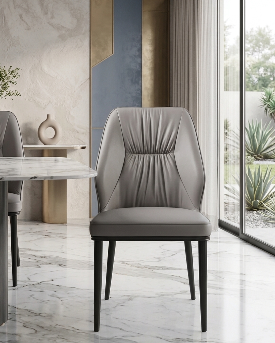 Premium taupe grey leatherette dining chair with pleated backrest design and sleek black metal legs viewed from the side profile in a modern home kitchen setup.